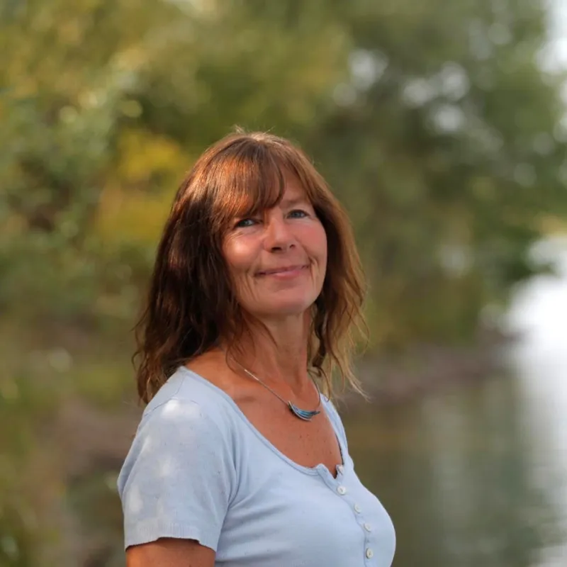 Christiane Heilmann lächelt, im Hintergrund ein See